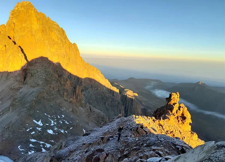 Sunrise illuminating rugged mountain ridges above high-altitude terrain